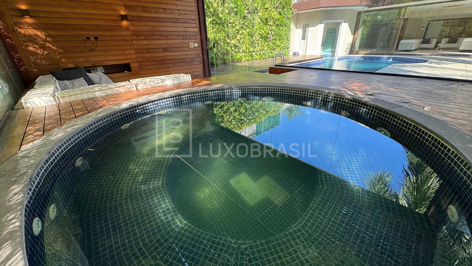 Spa em mosaico verde com vista para a piscina