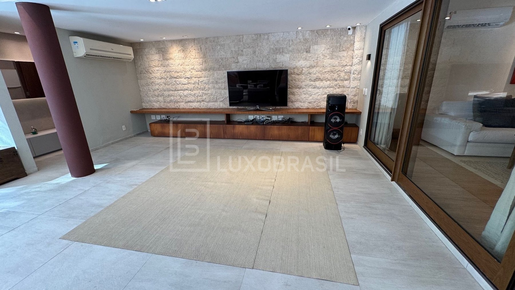 Home theater com painel de travertino e TV
