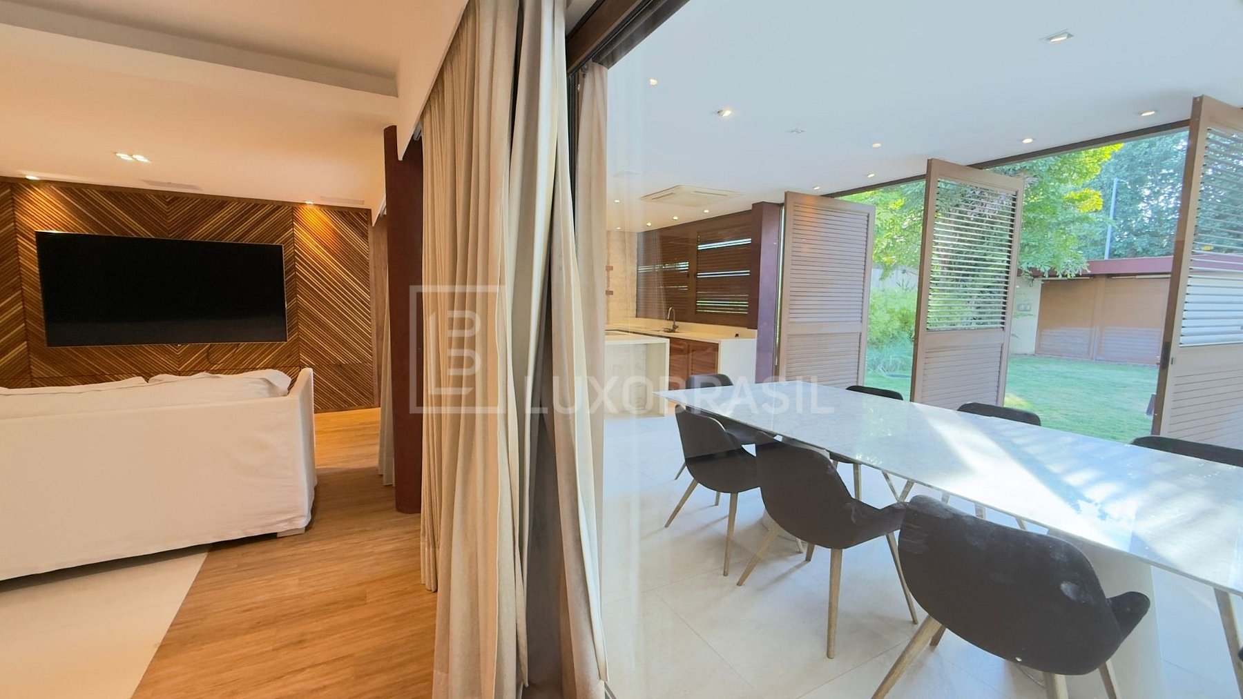 Sala de TV integrada ao jantar com vista para o jardim